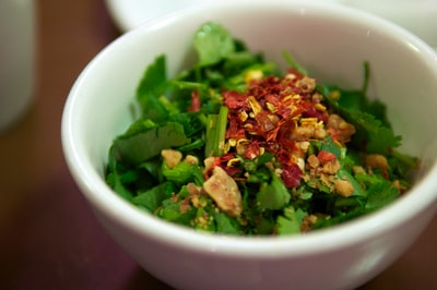 白色陶瓷碗中的绿色和红色蔬菜沙拉